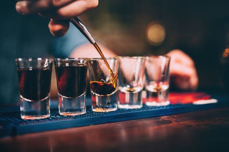 close up of shots being poured at a bar