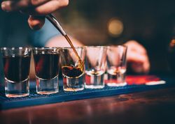 close up of shots being poured at a bar