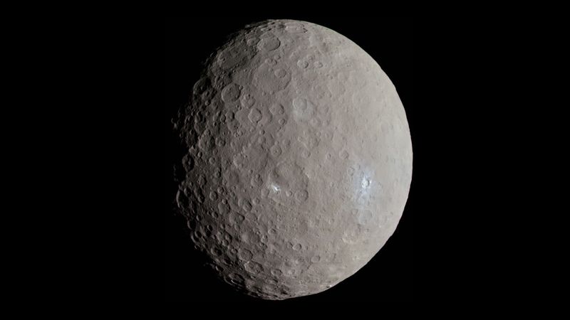 The dwarf planet is round with a cratered surface. Some region are bright and white evidence of geologicla activity like cryovolcanoes