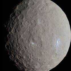 The dwarf planet is round with a cratered surface. Some region are bright and white evidence of geologicla activity like cryovolcanoes