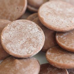 milk chocolate buttons with a white patchy coating on the surface, caused by fat or sugar bloom