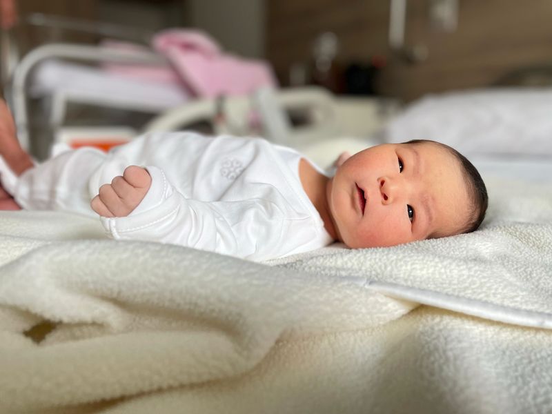 Baby born from the fertile procedure, lying on a blanket. 