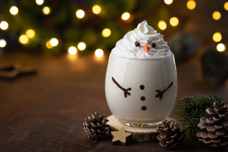 Delicious Christmas eggnog in glass. Creative snowman cocktail idea for Christmas and New Year Eve, copy space