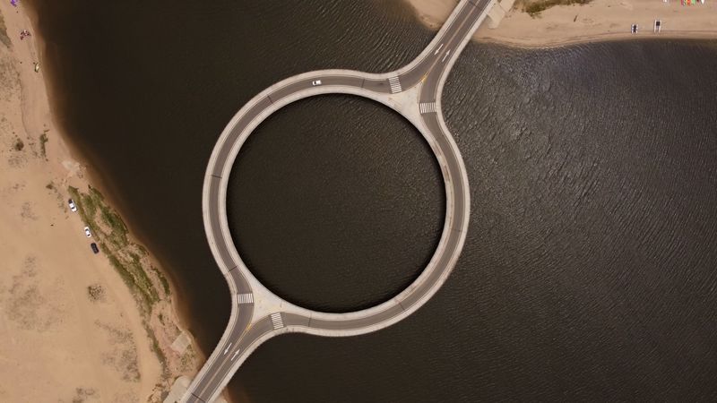 aerial view of Laguna Garzon Bridge, a circular bridge that connects sandy roads over a lagoon
