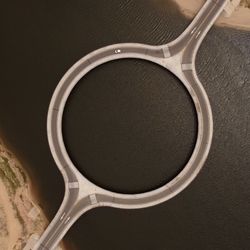 aerial view of Laguna Garzon Bridge, a circular bridge that connects sandy roads over a lagoon