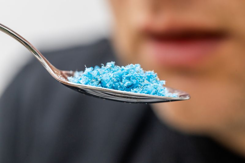representation of microplastics in food, small particles of blue plastic on a spoon