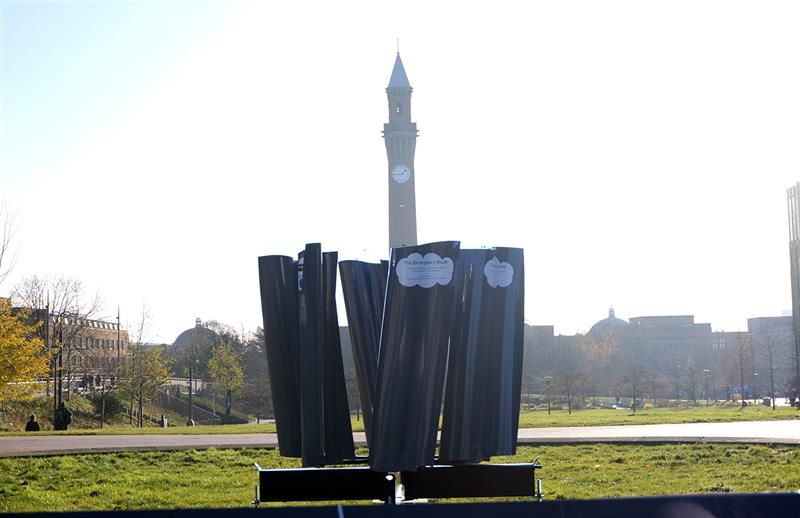 Photograph of the Birmingham Blade,a circle of vertical blades, with Old Joe clock tower in the background