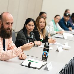 A table of different people sitting in a conference speaking