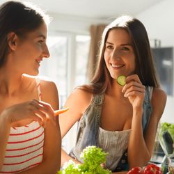 Healthy Eating Women Cooking Salad. Beautiful Smiling Vegan Girls Going To Eat Fresh Green Organic Vegetables In Kitchen. Happy People Enjoying Fitness Food. Detox Diet, Weight Loss Nutrition Concept