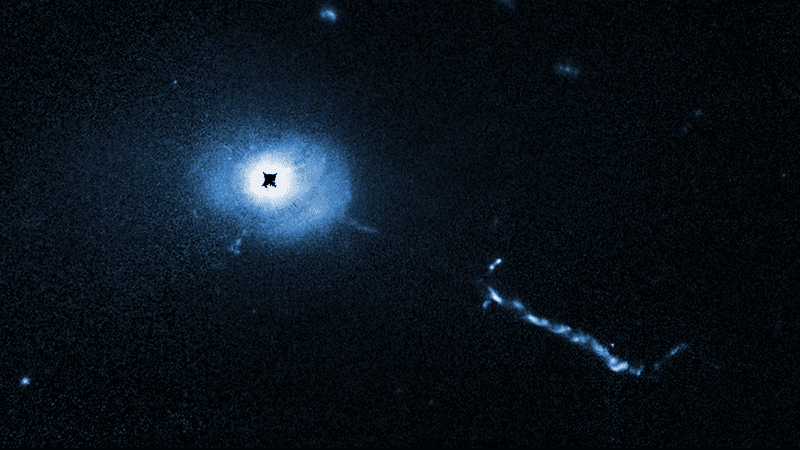 A Hubble Space Telescope image of the core of quasar 3C 273. A coronagraph on Hubble blocks out the glare coming from the supermassive black hole at the heart of the quasar. This allows astronomers to see unprecedented details near the black hole such as weird filaments, lobes, and a mysterious L-shaped structure, probably caused by small galaxies being devoured by the black hole. L