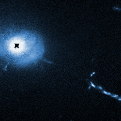 A Hubble Space Telescope image of the core of quasar 3C 273. A coronagraph on Hubble blocks out the glare coming from the supermassive black hole at the heart of the quasar. This allows astronomers to see unprecedented details near the black hole such as weird filaments, lobes, and a mysterious L-shaped structure, probably caused by small galaxies being devoured by the black hole. L