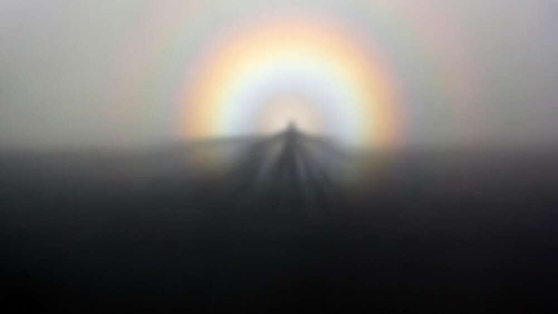 A brocken spirit cast on the mist, with a rainbow in the background. A brocken spirit cast on the mist, with a rainbow in the background.