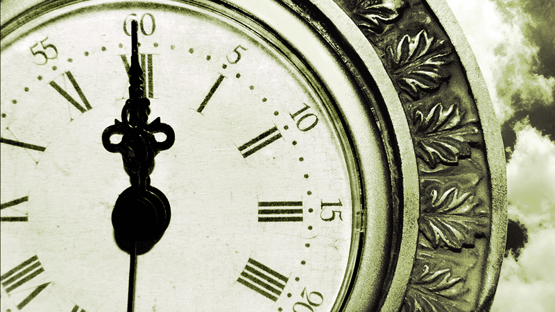 A clock face, with hands pointing towards 12.