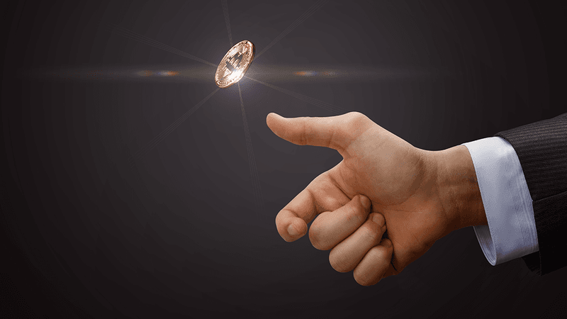 A hand tosses a coin into the air.