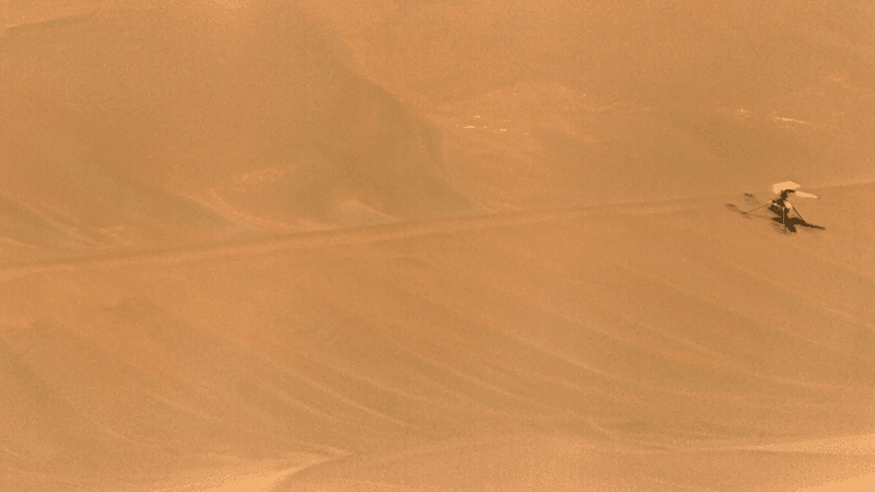 NASA’s Ingenuity Mars Helicopter, right, stands near the apex of a sand ripple 