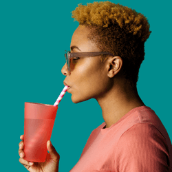 a woman drinking water out of a red cup through a straw