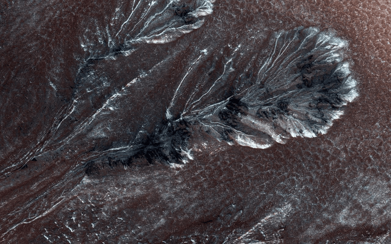 Frosty gullies on Mars' northern plains. We don't know if any of this currently falls as snow, but there's reason to think it might.