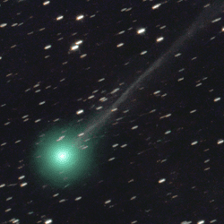 A bright green comet streaks across a star-filled dark backdrop of space