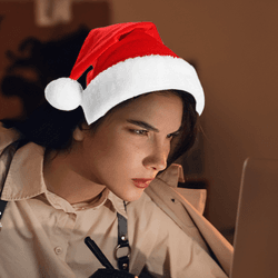 A woman spy working on a computer with a Christmas santa hat.