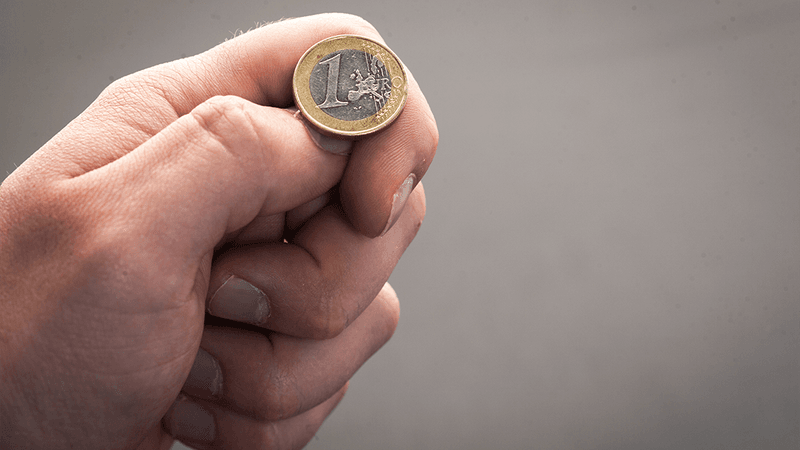 A hand about to flip a coin.