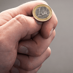 A hand about to flip a coin.